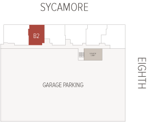 B2 unit highlighted in red on a building floor plan, positioned above a large garage parking area beside an elevator lobby, with Sycamore at the top and Eighth at the right.