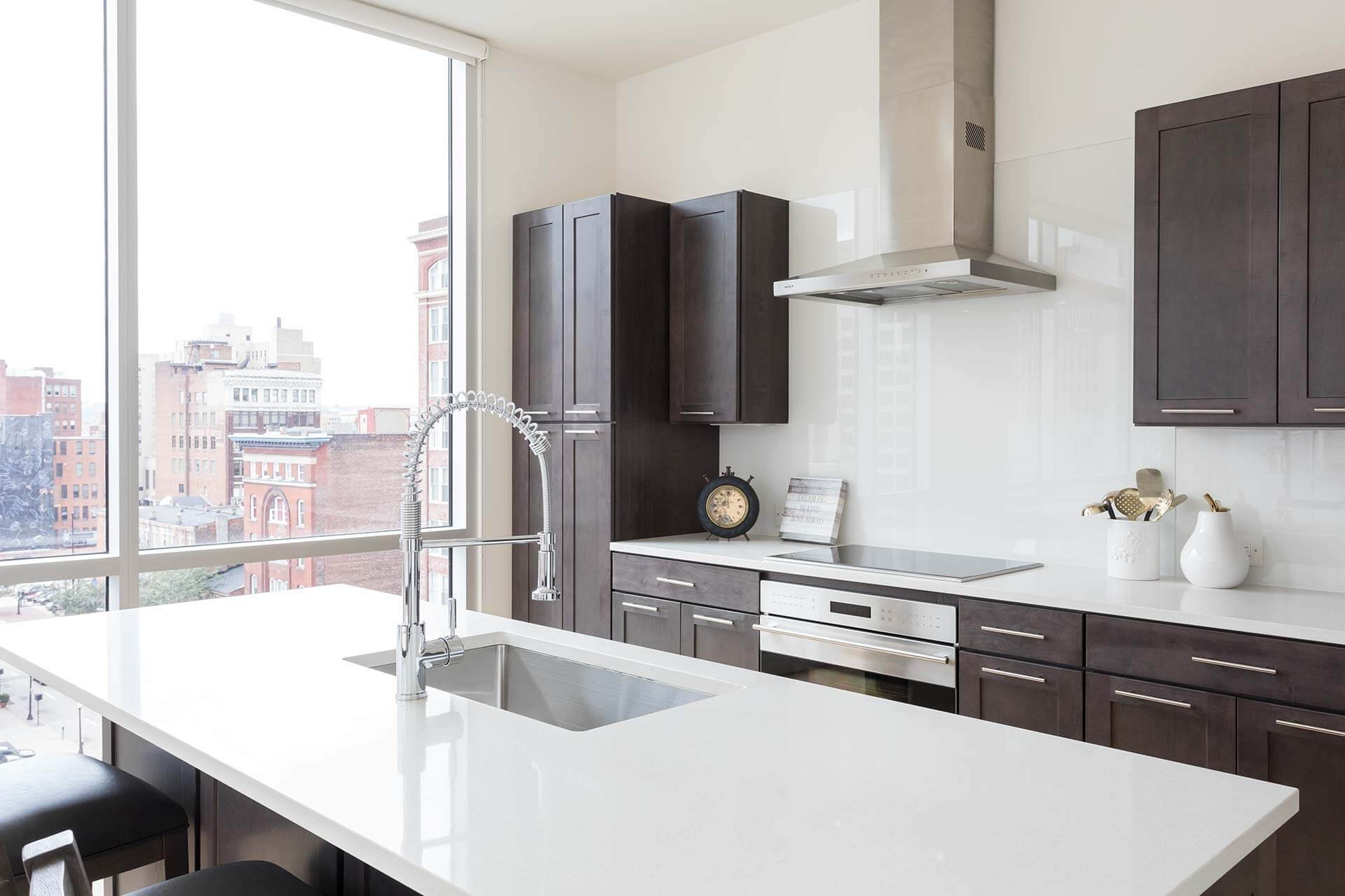 White kitchen island with chrome spring faucet sits above a sink