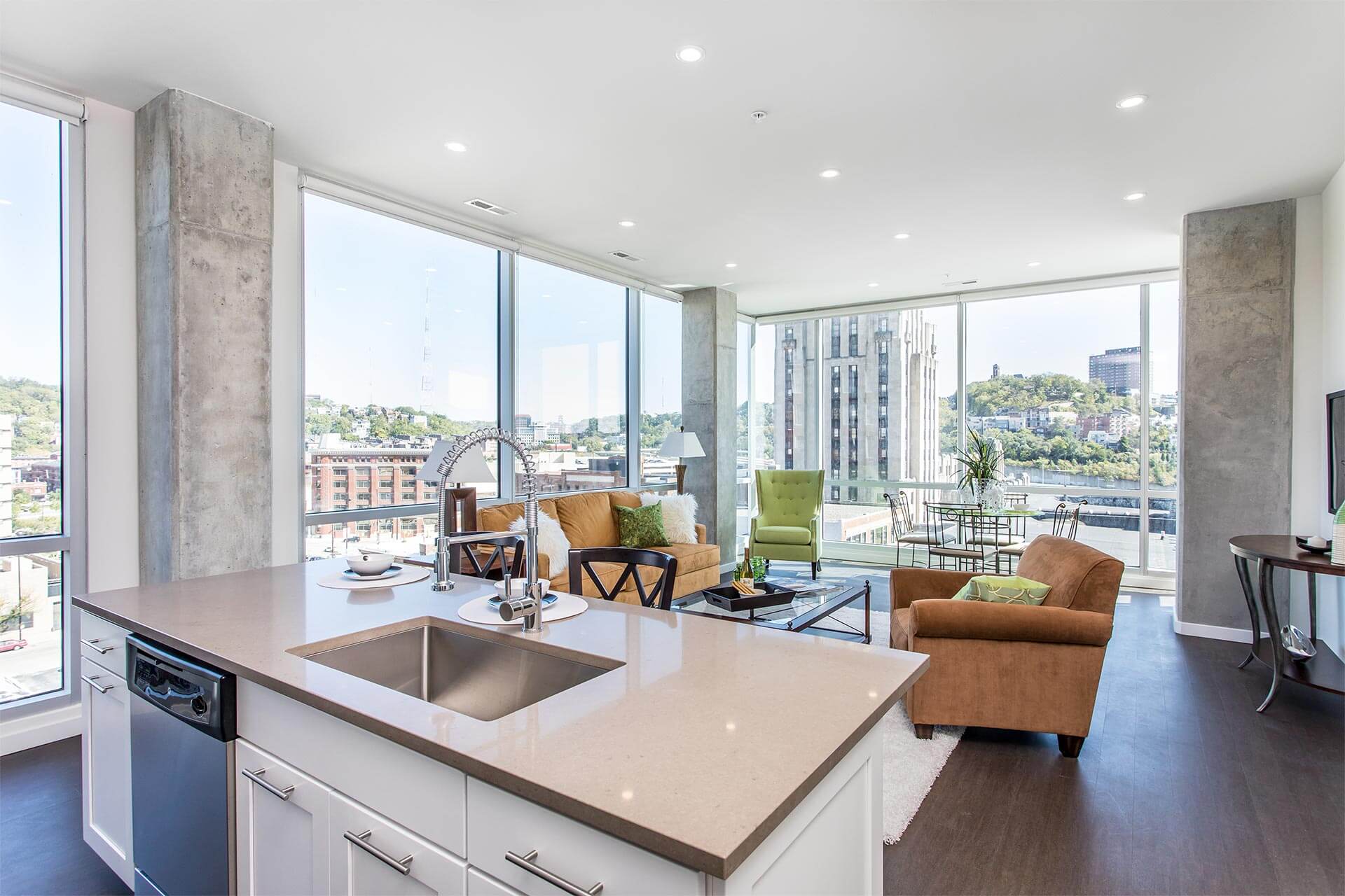 Kitchen island with stainless sink and coil-spring faucet occupies foreground